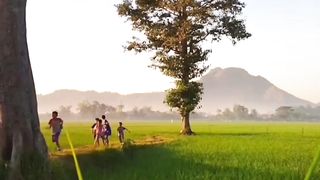 children are playing with the view of the vast rice fields and the beautiful mountains in Indonesia