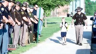 Cops escort a boy after his dad dies in the line of duty