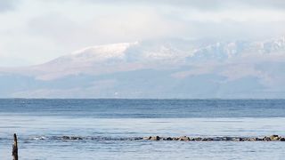 beautiful view of Arran with snow on the hills from Irvine beach