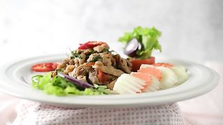 Rotating Stir Fried Pork Basil On A White Plate