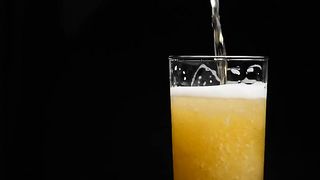 Beer Is Pouring Into Glass With Foam Sliding Down Side Of Beer Glass