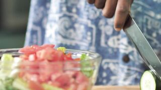 Man slicing cucumber for salad