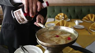 Chef in black suit cooking with fire