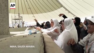 Muslim pilgrims cast first stones at pillar of Satan during Hajj.