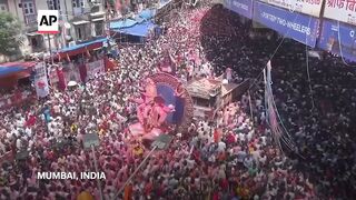 Huge crowd of Hindu faithful celebrates birthday of god Ganesha in India.