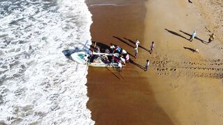 A group of people are riding in a boat on the beach