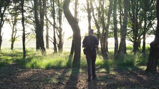 A Man Standing In The Middle Of The Forest