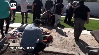 Mourners take cover at cemetery in Israel after rockets launched from Lebanon.