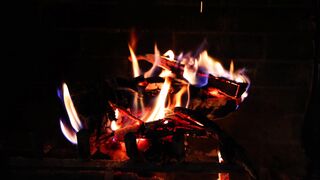 A fire with orange, yellow, and red flames burning in a fireplace.