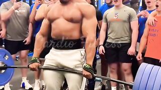 A weightlifter in the gym lifting heavy dumbbells.