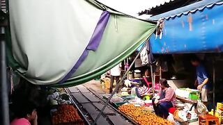 Thailand Maeklong train passing in the market