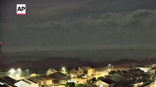 Explosions light up night sky over Gaza Strip.