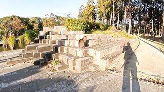 A cat comfortably lies on a brick after being touched by a person