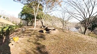 A cat lying on a table falls to the ground and a man touches it.