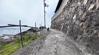 A cute black cat I met on a narrow road halfway up a mountain, rolling around when I pet it.