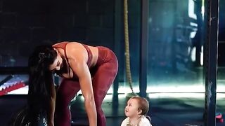 A mother exercises with her cute baby.