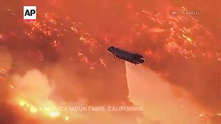 Associated Press - Helicopters battle flames as Palisades Fire burns