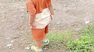 A toddler plays near a river.