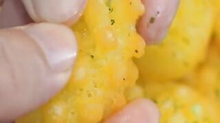 "Close-up of a golden crispy snack garnished with herbs"